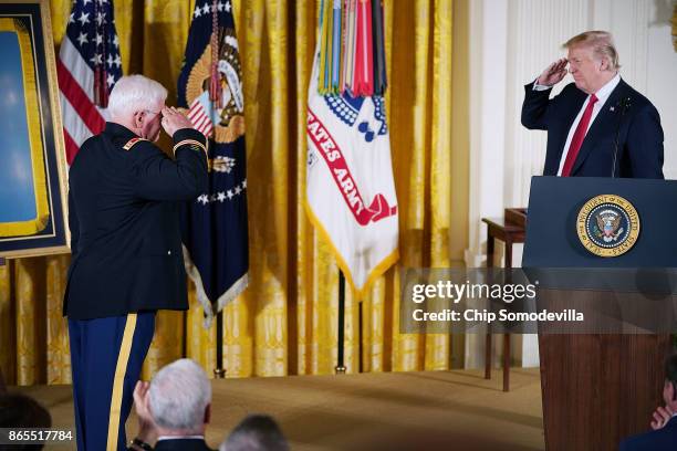 President Donald Trump salutes retired U.S. Army Capt. Gary Rose during his Medal of Honor ceremony in the East Room of the White House October 23,...