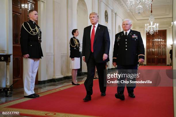 President Donald Trump and retired U.S. Army Capt. Gary Rose walk into the East Room for his Medal of Honor ceremony at the White House October 23,...