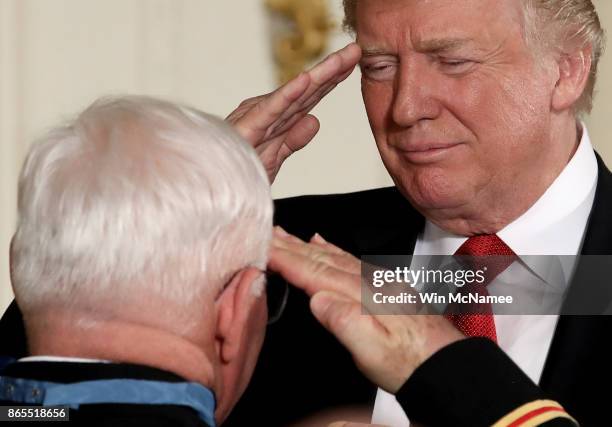 President Donald Trump salutes retired U.S. Army Capt. Gary Rose, of Huntsville, Alabama, before presenting him with the Medal of Honor during a...