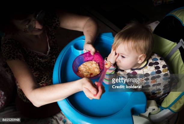 baby being fed by adult. picky eater toddler. - baby attitude stock pictures, royalty-free photos & images