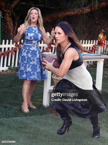 Football coach Dr. Jennifer Welter runs with football as TV personality Kym Douglas watches at Hallmark's "Home & Family" at Universal Studios...