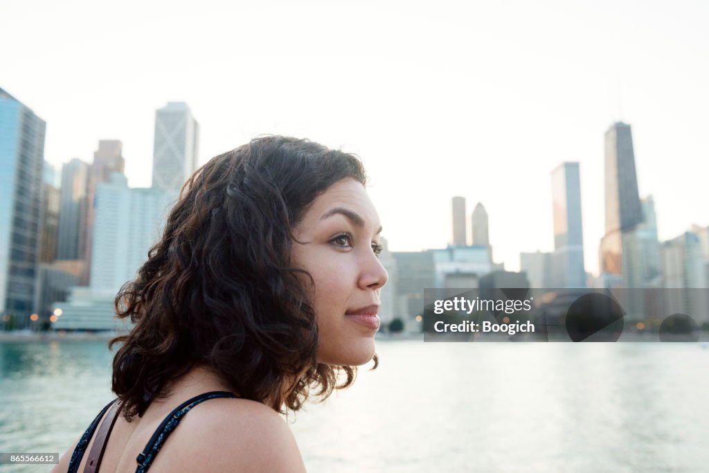 Millennial Hispanic Woman by Chicago Skyline in Contemplation