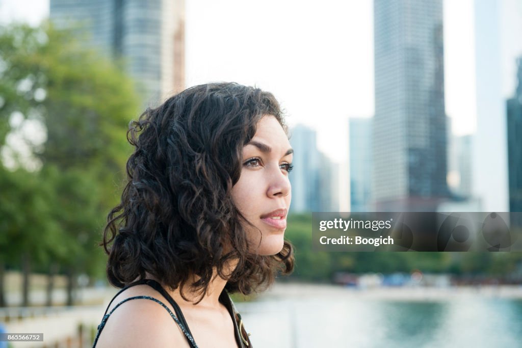 Millennial Hispanic Woman by Chicago Skyline in Contemplation