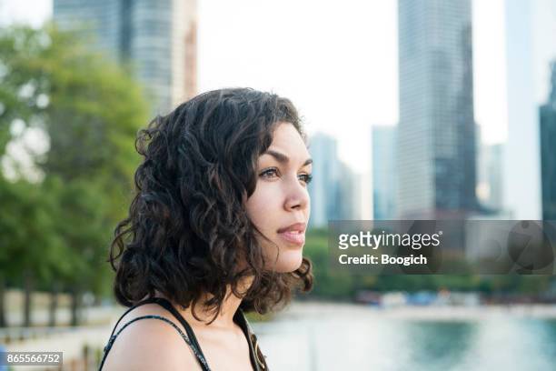 millennial hispanic woman by chicago skyline in contemplation - hot puerto rican women stock pictures, royalty-free photos & images