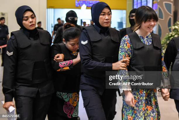 Vietnamese defendant Doan Thi Huong and Indonesian defendant Siti Aishah are escorted by police personnel at the low-cost carrier Kuala Lumpur...