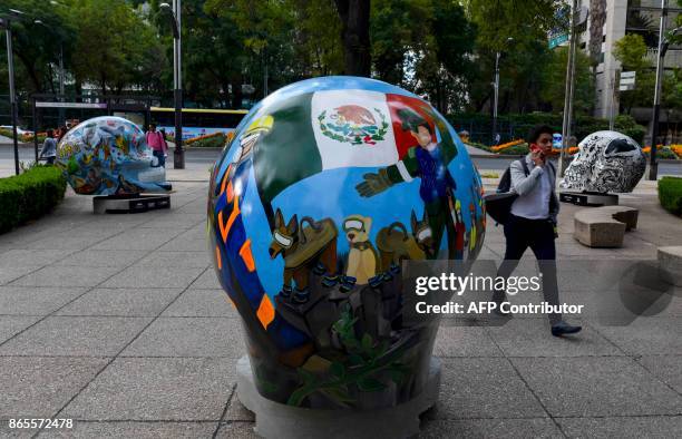 Man walks near a colorful skull painted by artist Natasha Kroupensky and titled "Mexico Volviendo a Florecer" at Reforma avenue in Mexico City on...