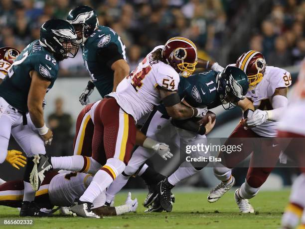 Carson Wentz of the Philadelphia Eagles is sacked by Mason Foster and Preston Smith of the Washington Redskins during the first quarter of the game...