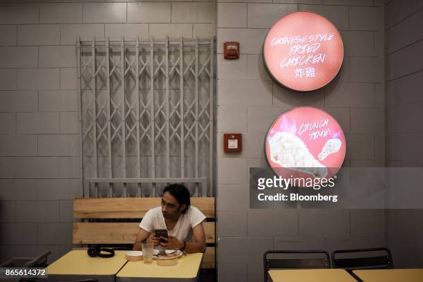 Customer uses his smartphone at a Chowking Food Corp. Chinese restaurant, operated by Jollibee Foods Corp., in the Bonifacio Global City triangle...