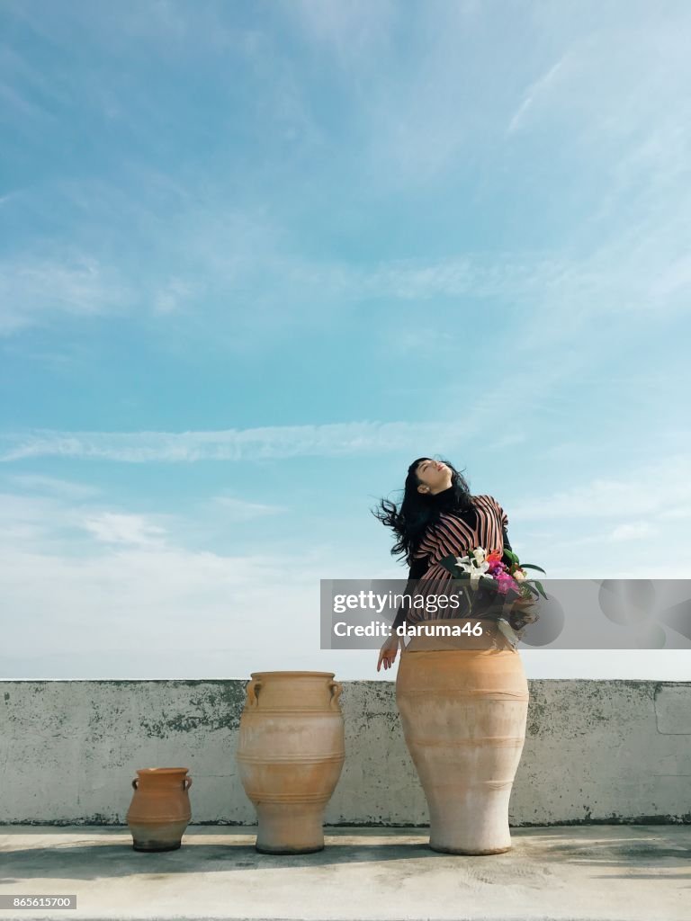 Donna in vaso di ceramica contro cielo