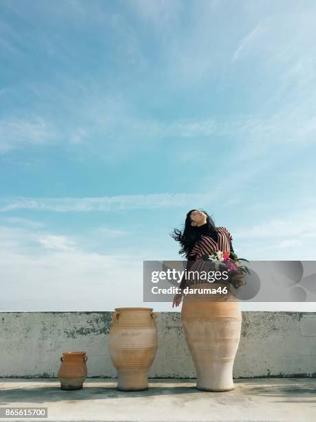 Woman in ceramic vase against sky