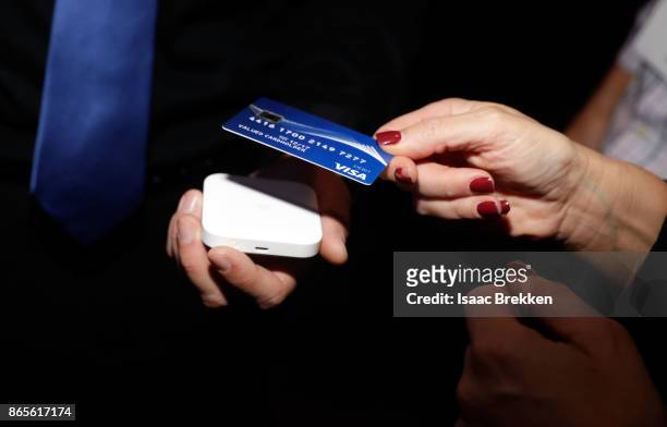 Guests tap to pay using contactless cards to support releif efforts during the Visa ID Intelligence launch party at Money 20/20 on October 23, 2017...