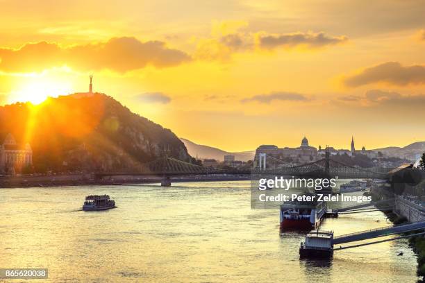 the gellert hill with the statue of liberty in budapest at sunset - royal palace budapest stock pictures, royalty-free photos & images