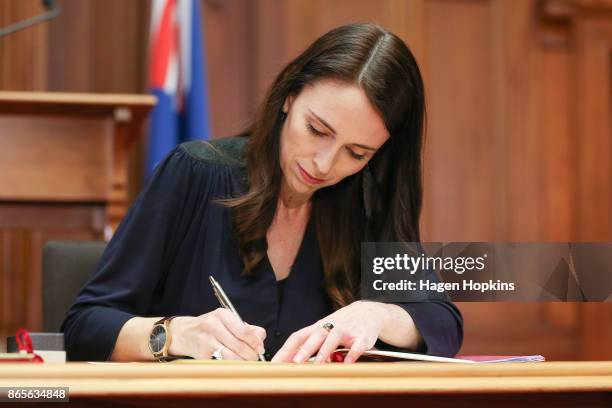 Prime Minister-designate Jacinda Ardern signs documents during a confidence and supply agreement signing at Parliament on October 24, 2017 in...