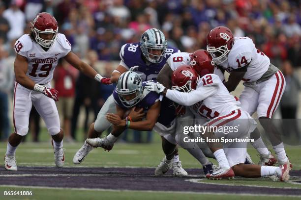 Oklahoma Sooners linebacker Kenneth Murray and defensive back Will Johnson tackle Kansas State Wildcats quarterback Alex Delton after a short gain in...