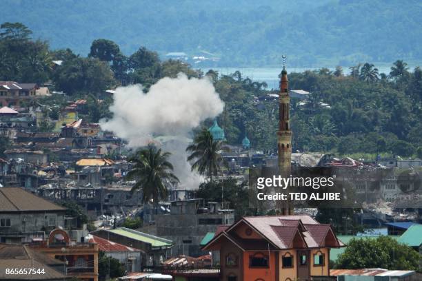 Smoke cloud from a controlled explosion by the military is seen as destroyed buildings and homes are seen at the main battle area of Marawi on the...