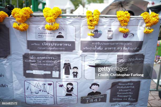Signs instruct the public of the strict dress and protocol for mourners attending the Royal Cremation of Thailand's late King Bhumibol Adulyadej on...