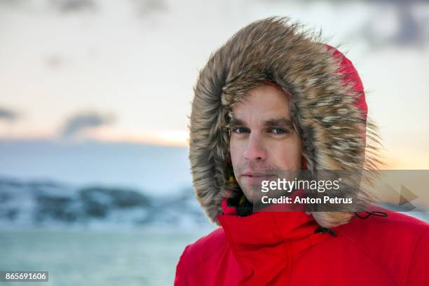 portrait of a young man on the shore of the northern sea - arctic explorer stock pictures, royalty-free photos & images