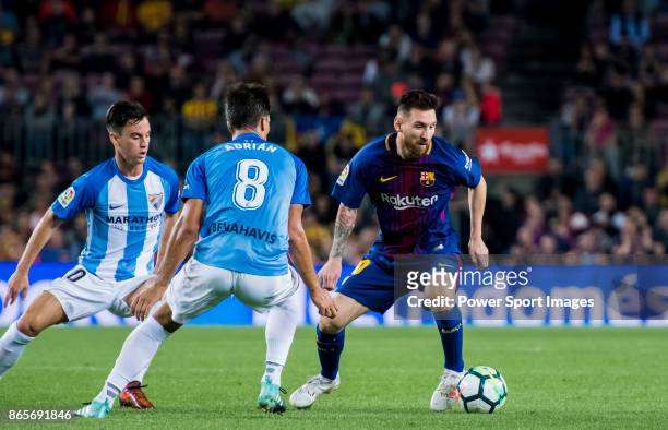 Lionel Andres Messi of FC Barcelona fights for the ball with Juan Pablo Anor Acosta, Juanpi and Adrian Gonzalez Morales of Malaga CF during the La...