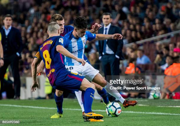 Juan Pablo Anor Acosta, Juanpi , of Malaga CF is tackled by Lucas Digne and Andres Iniesta Lujan of FC Barcelona during the La Liga 2017-18 match...