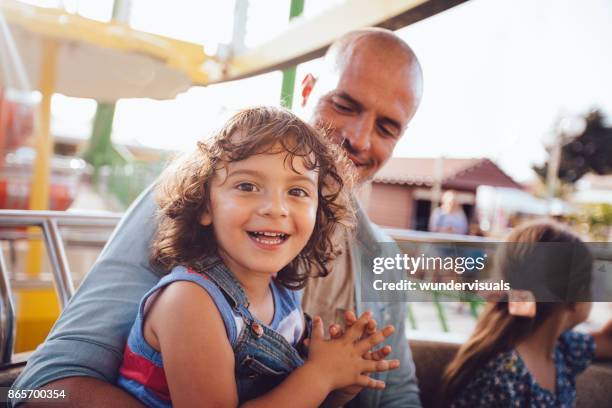 jonge kinderen met vader op ferris wheel amusement park ride - reuzenrad stockfoto's en -beelden