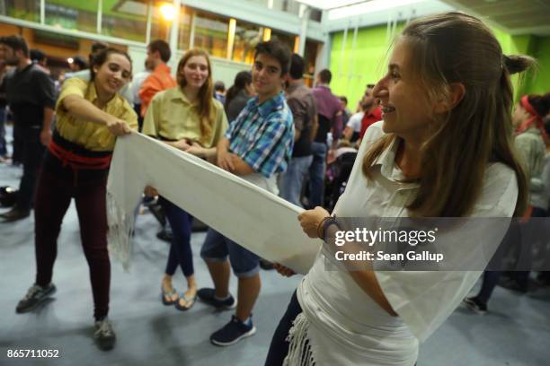 Sofia Clares assists fellow "casteller" Elena Colet of the Castellers de Sants human tower group put on a "faixa," a sash the castellers use to...