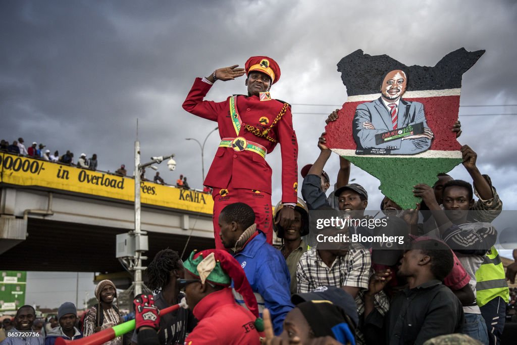 A supporter of Kenya's president Uhuru Kenyatta salutes from the ...