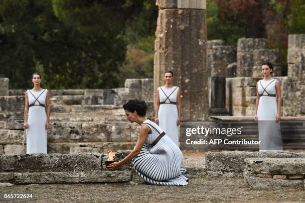 Actress Katerina Lechou , acting the high priestess, holds the Olympic flame at the Temple of Hera in Olympia, the sanctuary where the Olympic Games...