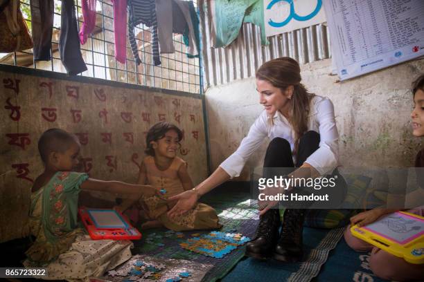 In this handout image supplied by the Jordanian Royal Court, Queen Rania of Jordan meets Rohingya muslim refugees during her visit to the Kutupalong...
