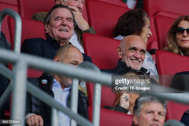 Former German chancellor Gerhard Schroeder sits happy in the stands next to Martin Kind, chairman of Hannover, during the Bundesliga match between FC...