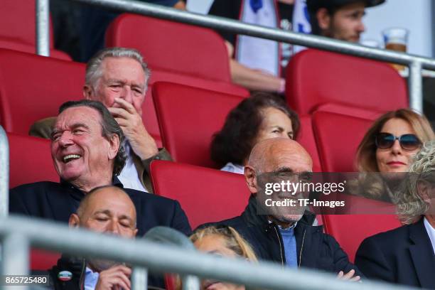 Former German chancellor Gerhard Schroeder sits happy in the stands next to Martin Kind, chairman of Hannover, during the Bundesliga match between FC...