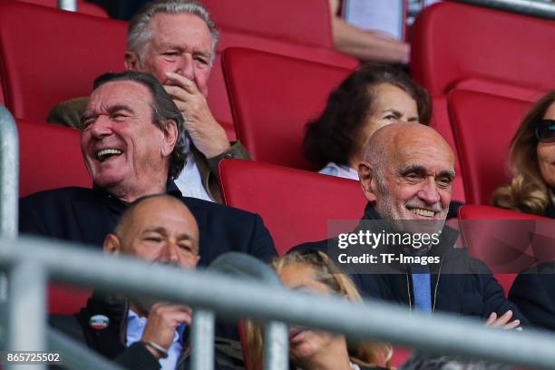 Former German chancellor Gerhard Schroeder sits happy in the stands next to Martin Kind, chairman of Hannover, during the Bundesliga match between FC...