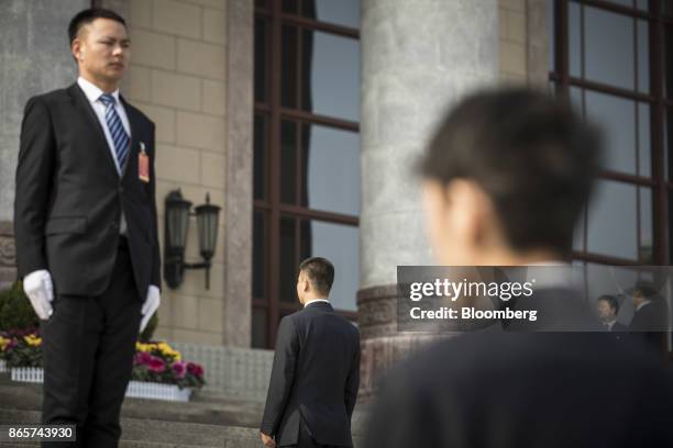 Security personnel stand guard outside the Great Hall of the People following the closing session of the 19th National Congress of the Communist...