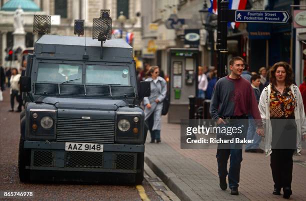 Shoppers walk past a reinforced RUC Land Rover Tangi vehicle in the city centre, on 7th June 1995, in Belfast, Northern Ireland, UK.