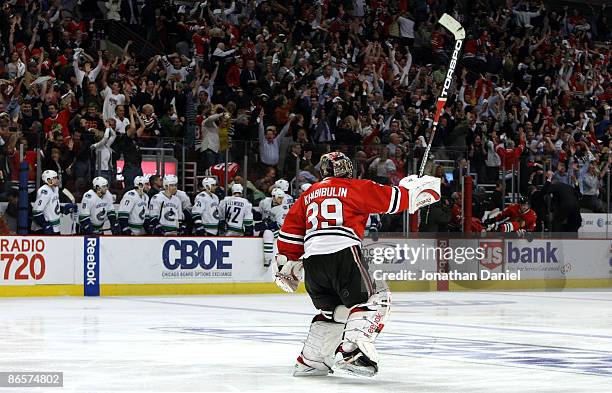 Goalie Nikolai Khabibulin of the Chicago Blackhawks celebrates along with the fans as he skates past a dejected Vancouver Canucks bench after the...