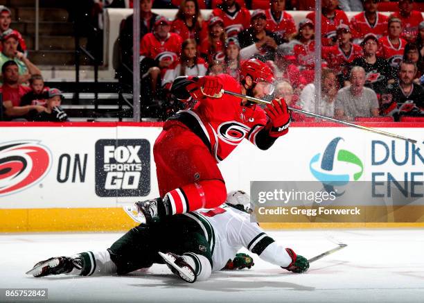 Jordan Staal of the Carolina Hurricanes leaps over the defense of Kyle Quincey of the Minnesota Wild during an NHL game on October 7, 2017 at PNC...