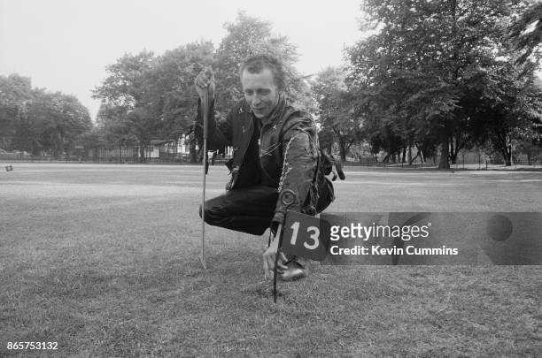 Ian, a punk, retrieves his ball from hole no 13 while playing miniature golf, 1977.