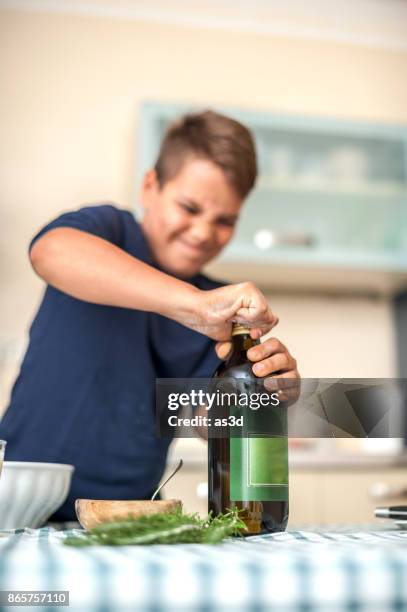 boy struggling to take lid off the bottle - lid stock pictures, royalty-free photos & images