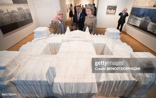 Artist Christo talks to Queen Mathilde of Belgium by a model of the 1995 project "Wrapped Reichstag" during a visit of the exhibition "Christo and...