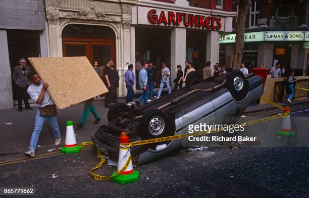 The clean-up begins the morning after the Poll Tax riot, on 1st April 1990, in Charing Cross Road, London, England. Angry crowds, demonstrating...