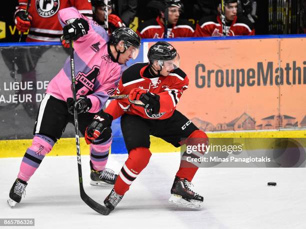 Anthony Poulin of the Blainville-Boisbriand Armada and Pierrick Dube of the Quebec Remparts battle for the puck during the QMJHL game at Centre...