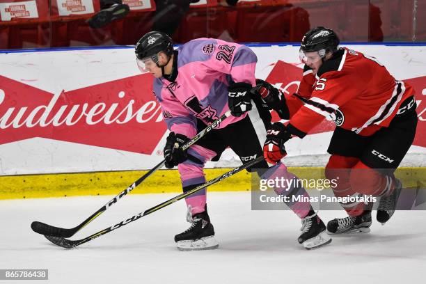 Alexander Katerinakis of the Blainville-Boisbriand Armada skates the puck against Sam Dunn of the Quebec Remparts during the QMJHL game at Centre...