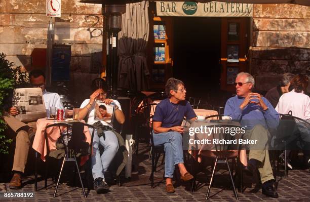 Cafe couple read a copy of Correre della Sera newspaper and a womens' magazine in the Italian capital, on 3rd November 1999, in Rome, Italy.