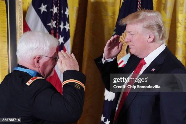 President Donald Trump salutes retired U.S. Army Capt. Gary Rose during his the Medal of Honor ceremony in the East Room of the White House October...