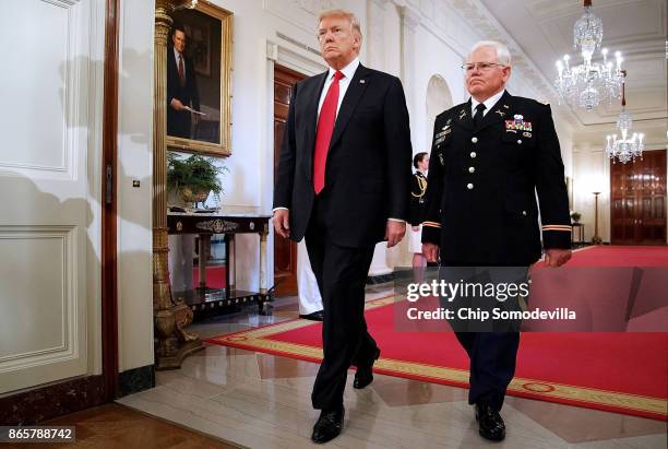 President Donald Trump and retired U.S. Army Capt. Gary Rose walk into the East Room for his Medal of Honor ceremony at the White House October 23,...