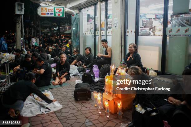 People begin to queue and sleep in shop doorways and on the streets overnight to attend Thailand's late King Bhumibol Adulyadej's cremation and...