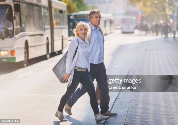 senior couple in the city - couple crossing street stock pictures, royalty-free photos & images