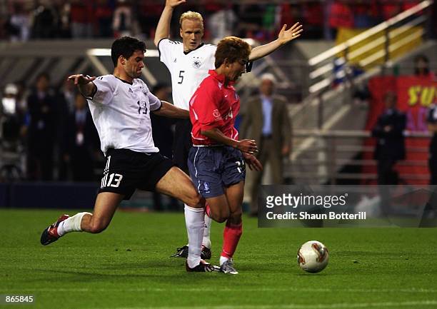Michael Ballack of Germany makes the tackle on Chun Soo Lee of South Korea that resulted in him getting a yellow card which due to a previous booking...