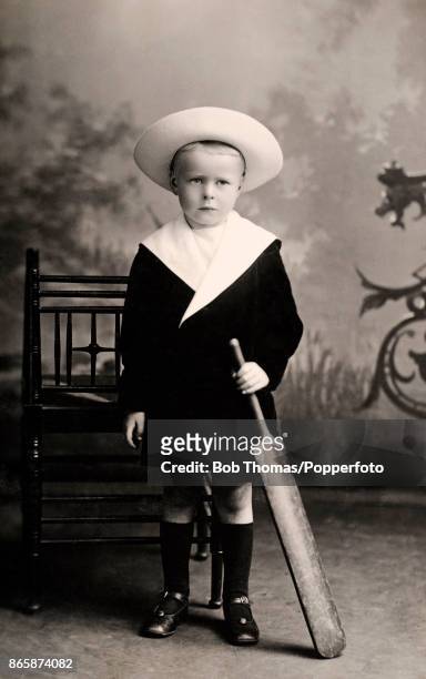 Studio portrait of a young boy wearing a sailor suit and holding a cricket bat in Aberdeen, Scotland, circa September 1914.
