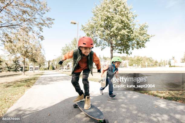 irmãos, se divertindo com longboard - skater pro - fotografias e filmes do acervo
