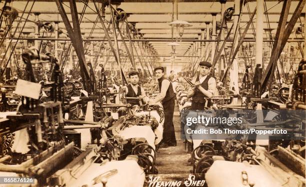 Labourers at work in a weaving shed in a textile manufacturing factory in Bristol, circa 1920.